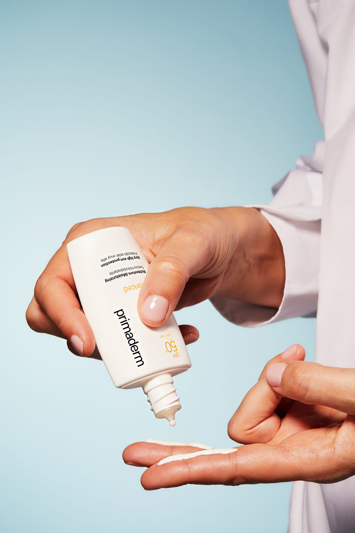 Hands applying XpertSun Urban Advanced Rich sunscreen