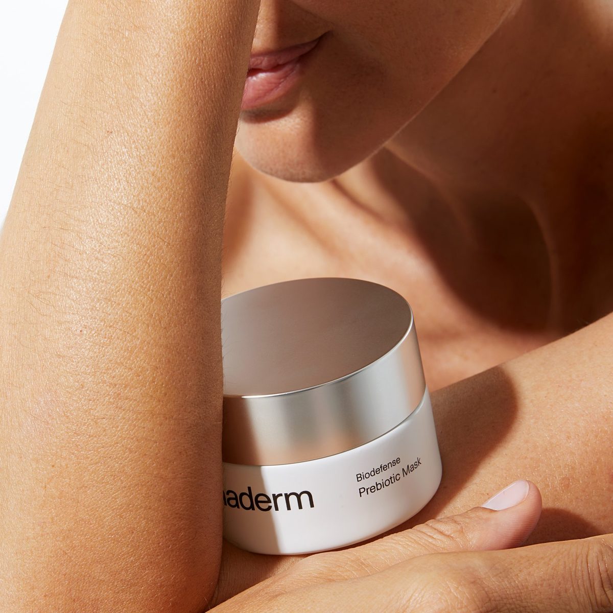 Woman holding a jar of Biodefense Prebiotic Mask