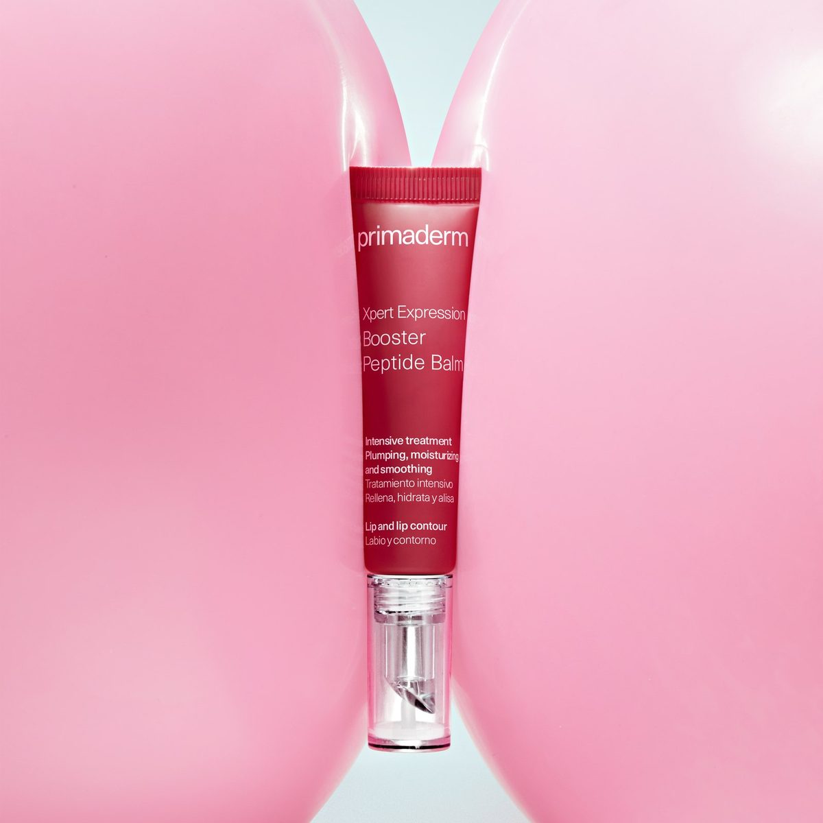 Booster Peptide Balm tube between two pink balloons